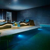 A relaxation pool with underwater lighting with heated loungers