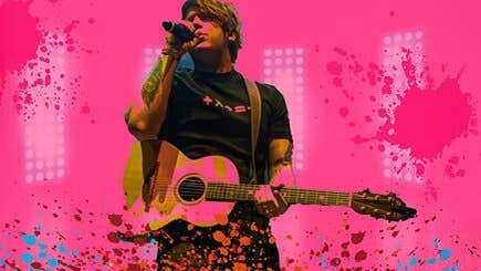 A man with a guitar singing into a mic with pink background and splashed colours across the bottom edge.