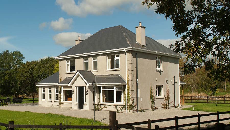 Exterior of house with garden enclosed by timber fence
