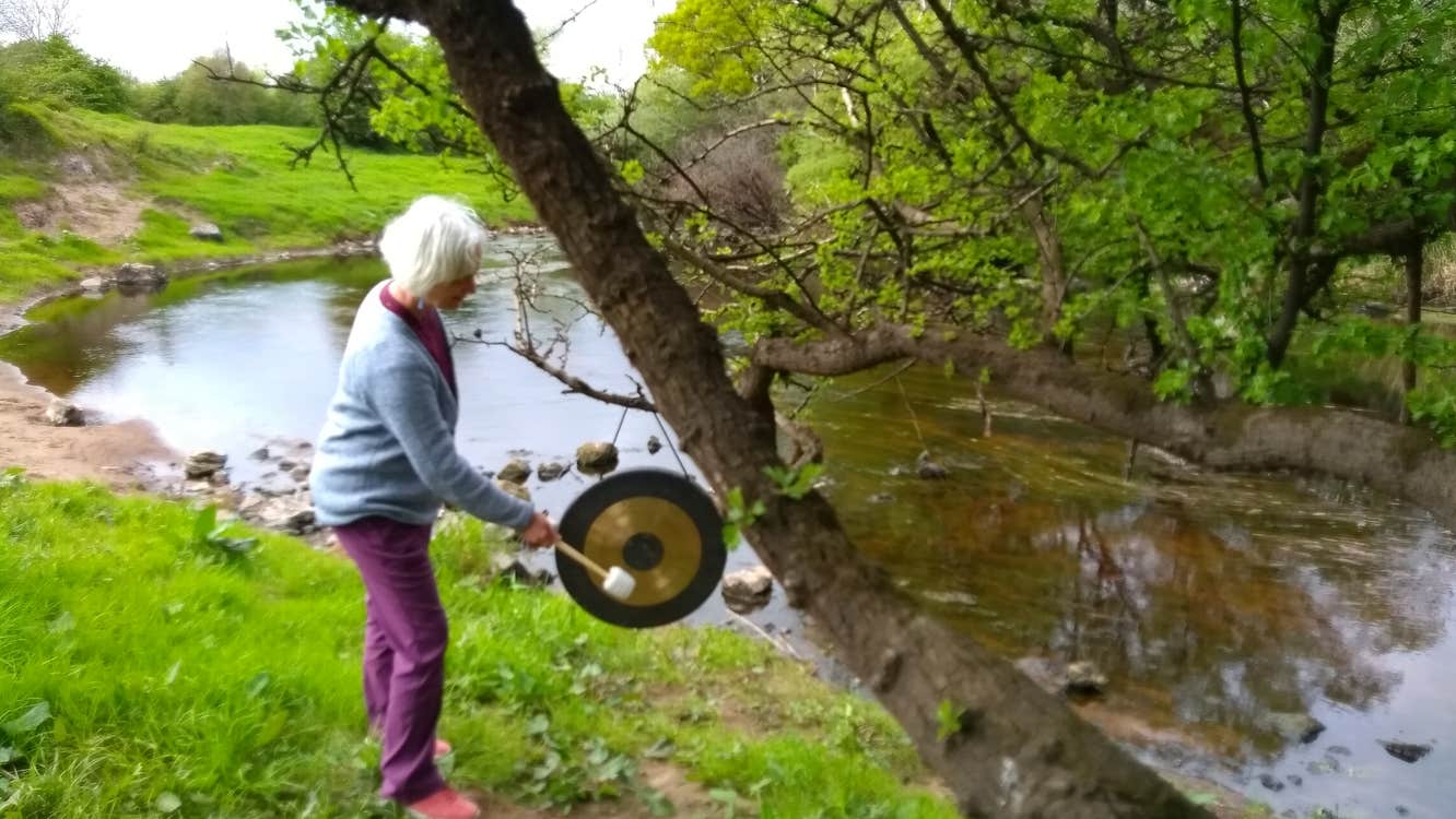 The guide Jackie using sound healing by a tree