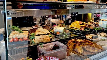 Glass shelving in a tea room with food decoratively displayed