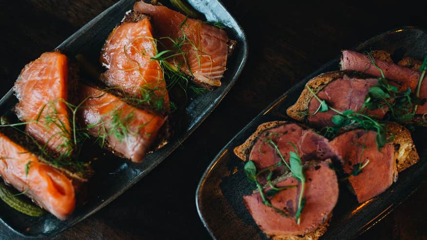 Fish and beef dishes on a black background.