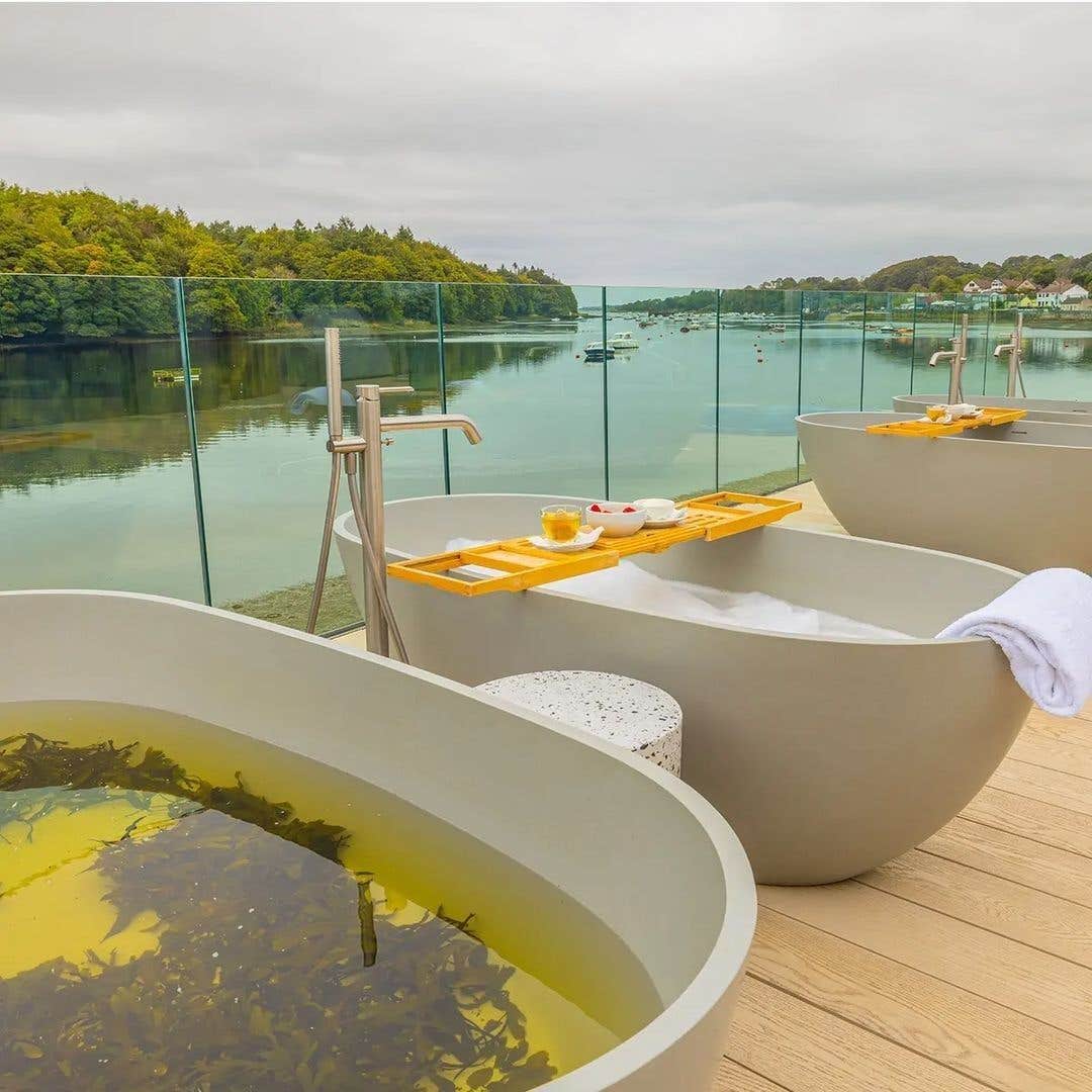 A line of seaweed baths on a wooden deck overlooking the water in Ballina, Mayo at The Ice House Hotel.