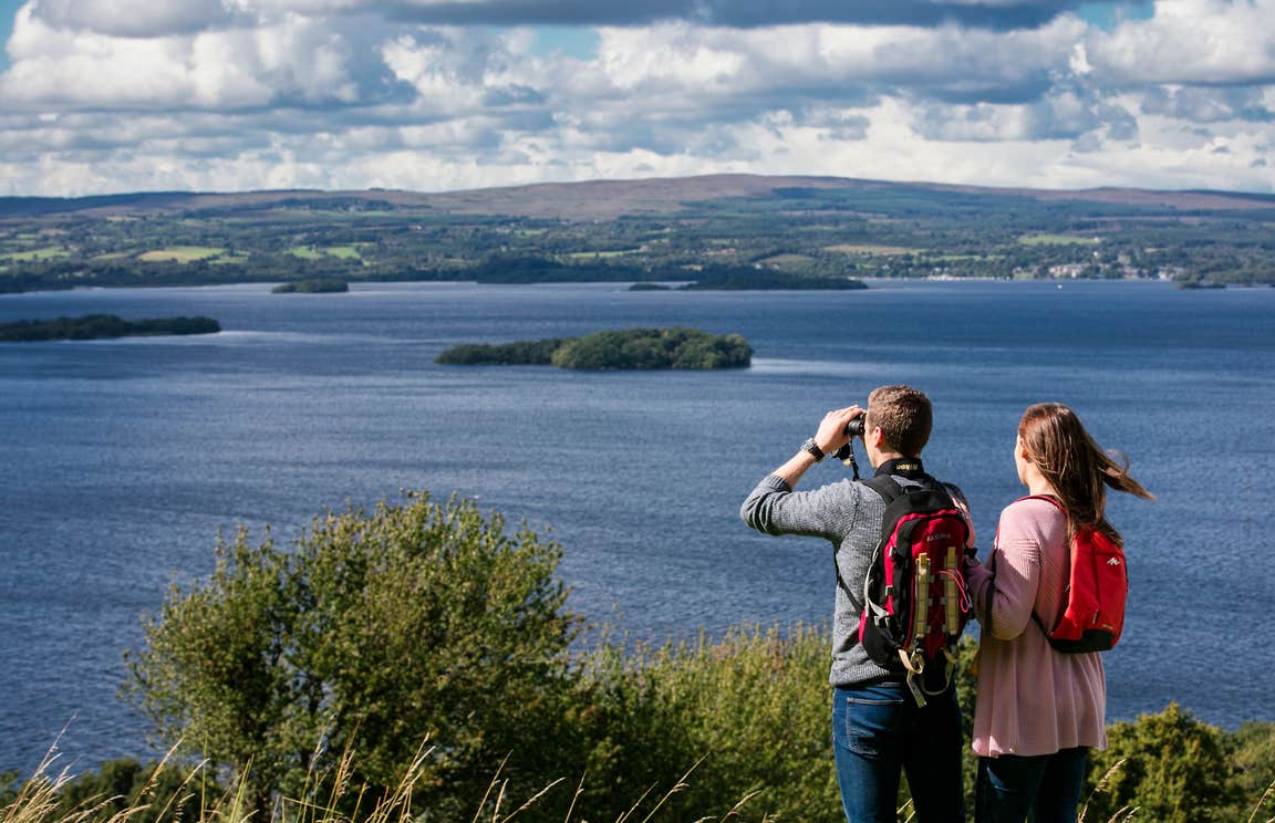 A couple using binoculars to look out over Lough Derg, County Tipperary