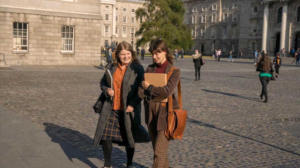 A scene from the Irish tv series 'Normal People', showing two girls walking through Trinity College campus.