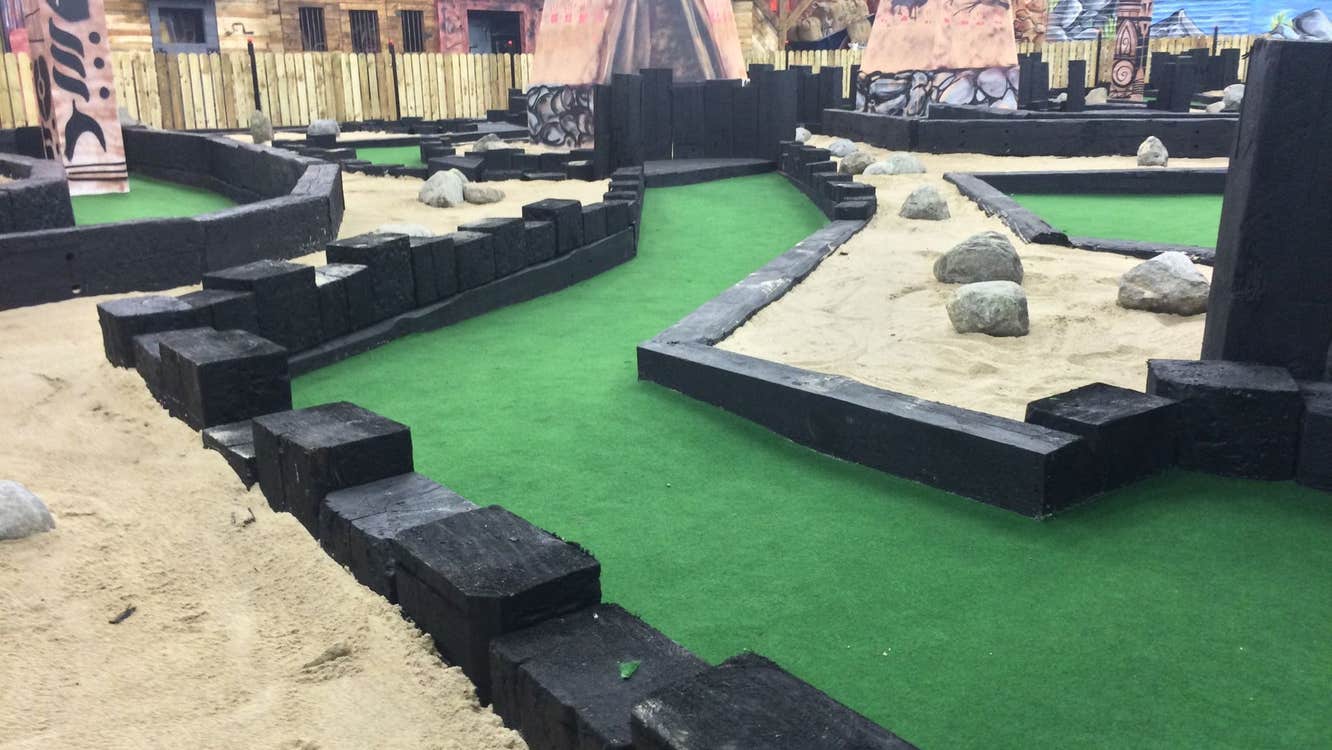 An indoor play area for kids with sand and small buildings to explore