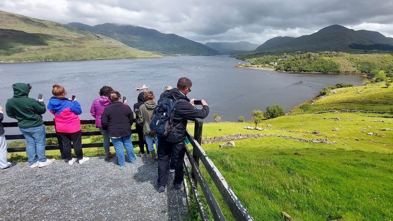 A tour group at a viewing point looking out onto a lake
