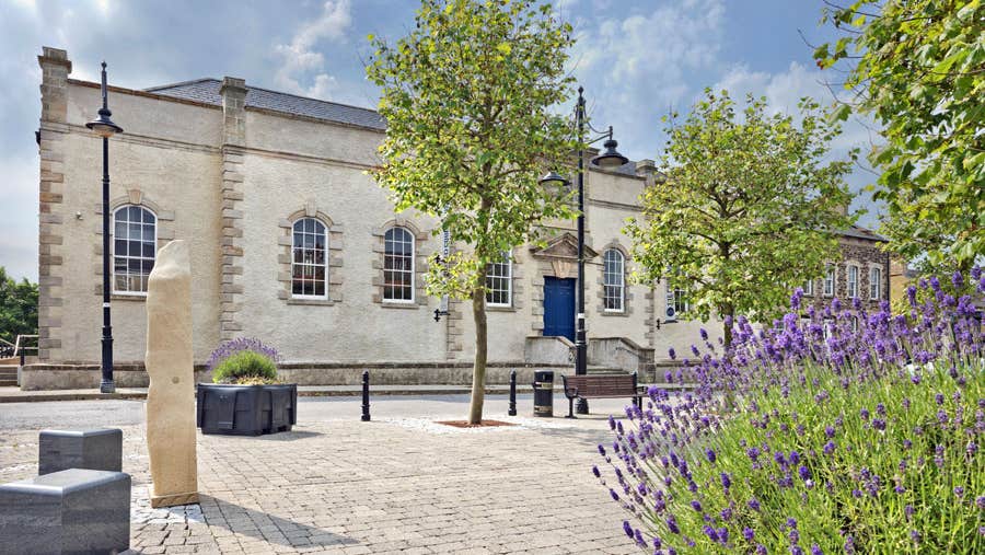 View of Lifford Old Courthouse with trees and shrubs in front