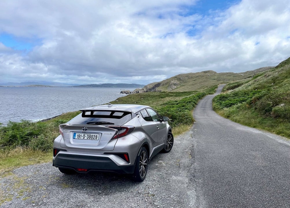 A large car parked beside the coast