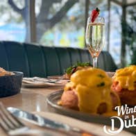 Image of brunch display with eggs royale, and a glass of prosecco