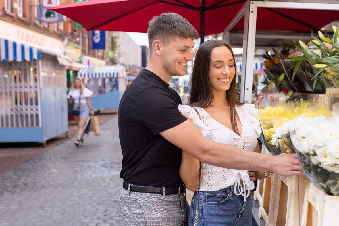 A couple looking at flowers on Moore Street.