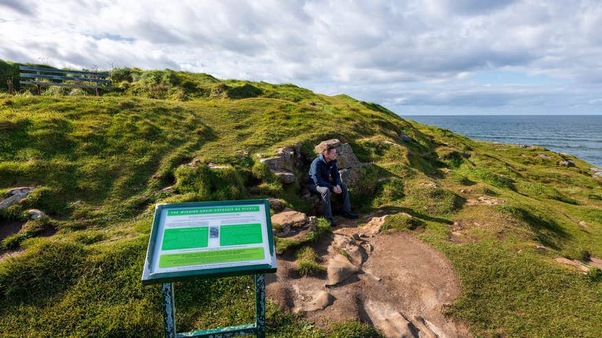 A man sitting on the Wishing Chair on the Rougey Walk in Bundoran, Donegal