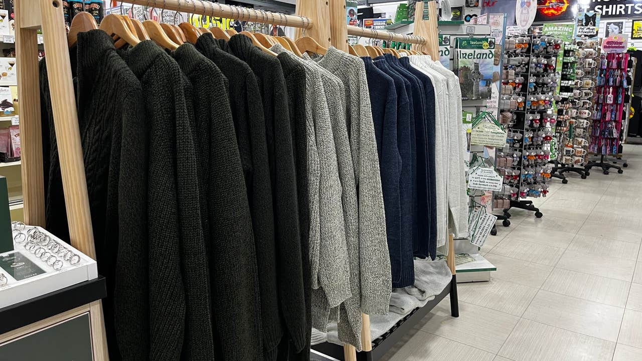 Selection of woollens on a rail surrounded by other Irish gifts and souvenirs for sale