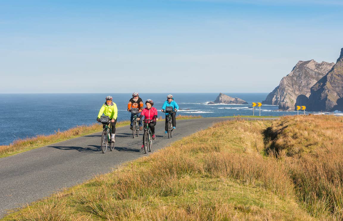 Family cycling along the coast in Donegal