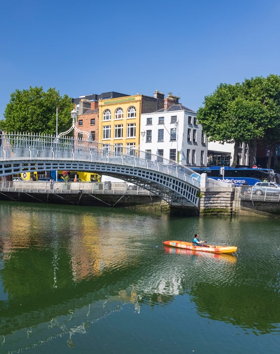 A person kayaking under the Ha'penny Bridge in Dublin city