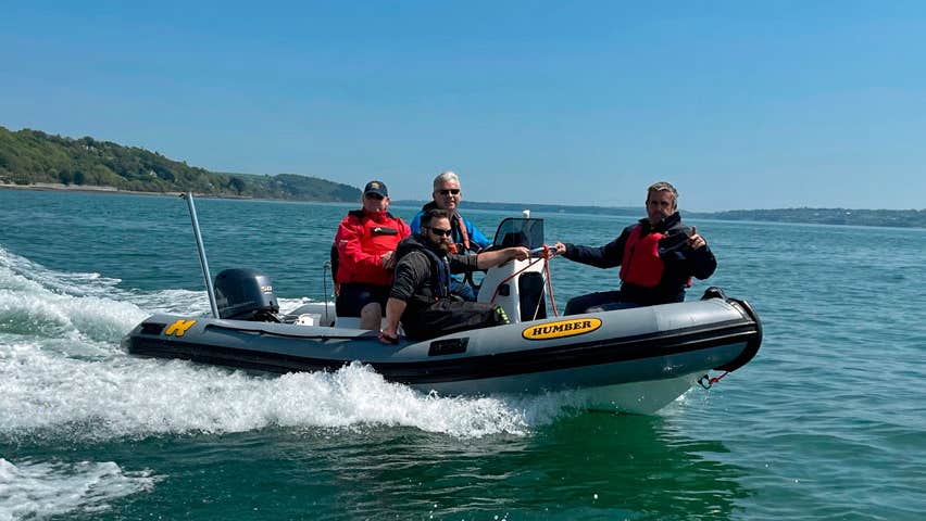 Four men on a motor powered dinghy on the sea
