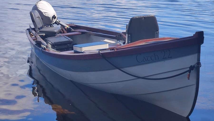 Small boat called Catch 22 moored up on a lake