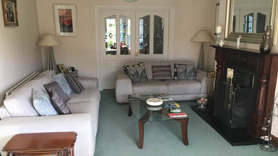Sitting-room with cream chairs and green carpet