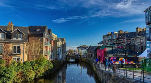 A view of apartments and street art along the still waters of Eglington Canal in Galway.