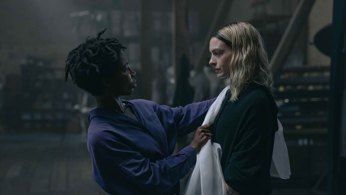 A woman is putting a shawl on another woman.
