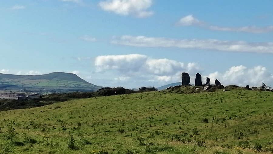 A view of the Eightercua four standing stones on a hilly mound