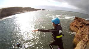 A person diving into the water from a cliff top with Wild Water Adventures in County Kerry.
