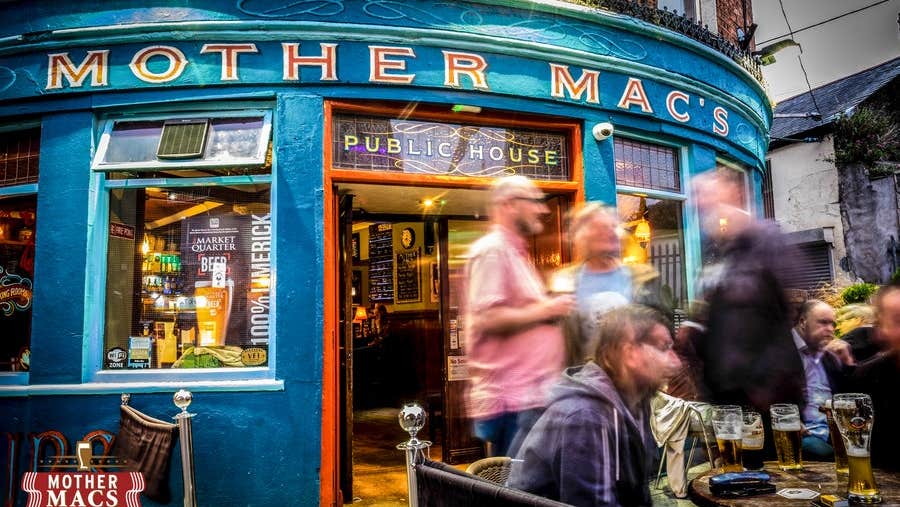 The exterior of Mother Macs pub with people standing outside