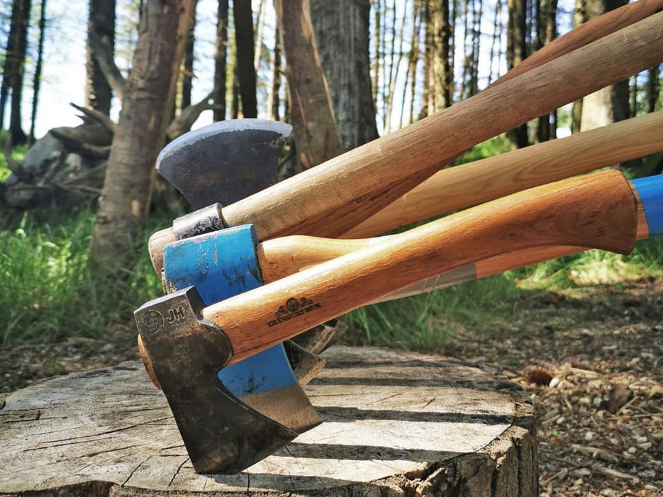 Axe Club view of four axes embedded in wood slab