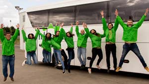 Tour group jumping in front of bus