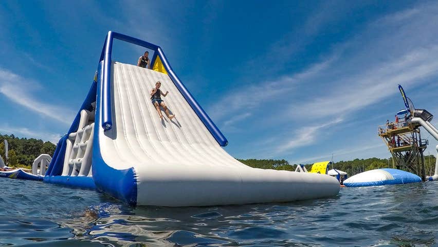 Someone sliding down an inflatable slide on a lake