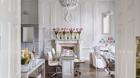 Nail salon with desk and chairs with flowers in vases