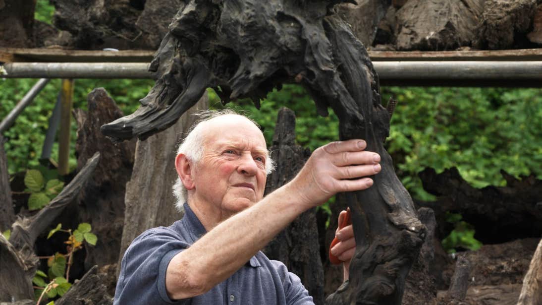 Man creating a piece of art at Bog Oak Sculpture, Longford