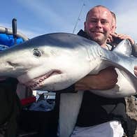 Man holding a blue shark