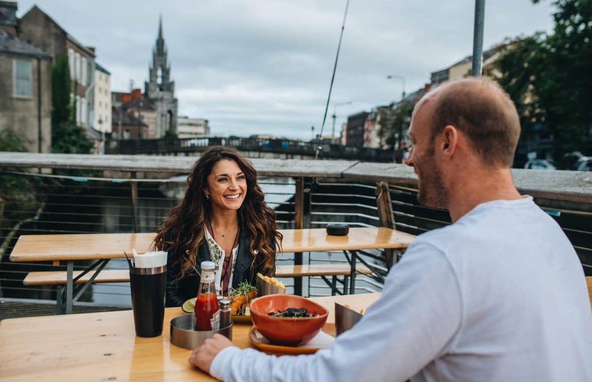 Couple dining by the River Lee in Cork City.