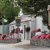 Exterior of a tearoom with stone walls and colourful flowers