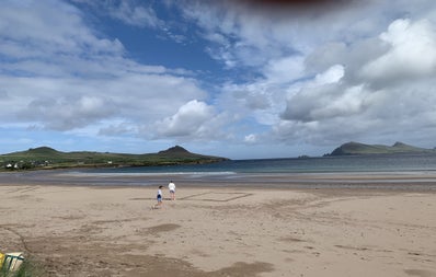 A couple walking on the sand at a beach along the Dingle Peninsula