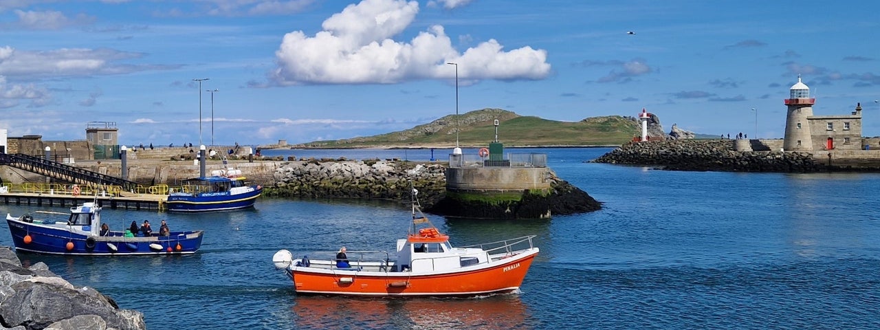 A small ferry boat departing a harbour