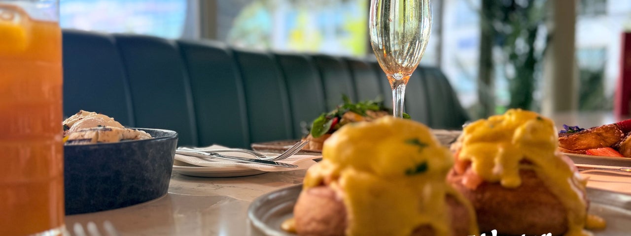 Image of brunch display with eggs royale, and a glass of prosecco
