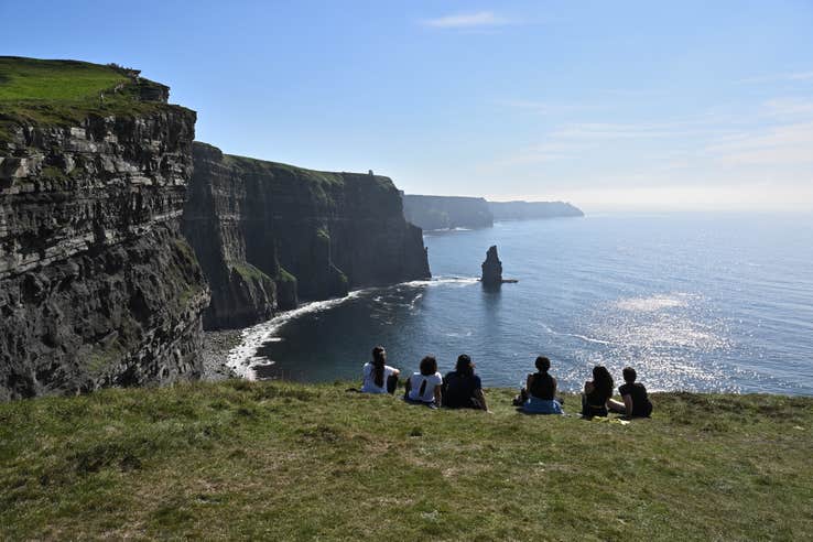 People sitting on the Cliffs of Moher in Clare