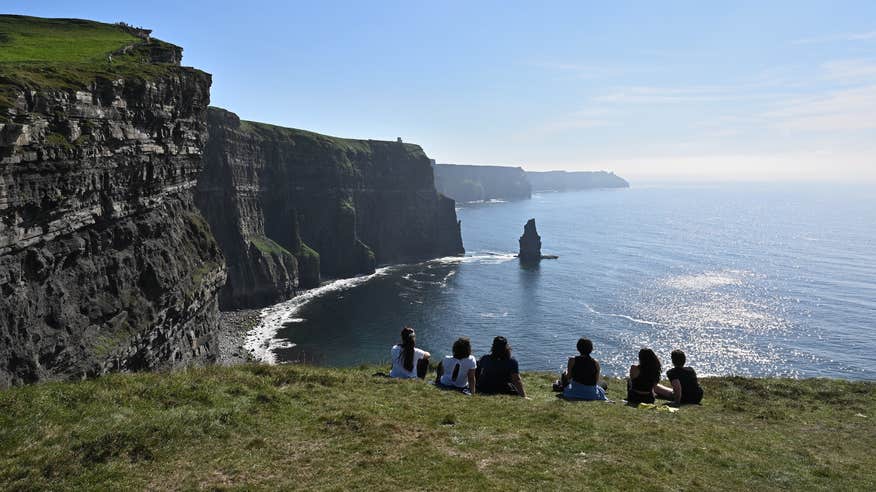 People sitting on the Cliffs of Moher in Clare