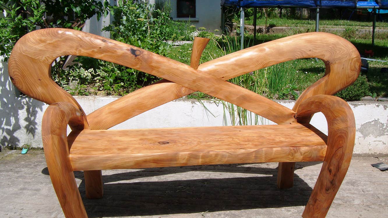 Architectural Furniture wooden garden bench with curved lines crossing in back