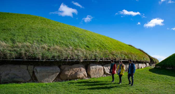 People walking beside the Knowth Neolithic tomb in Co Meath