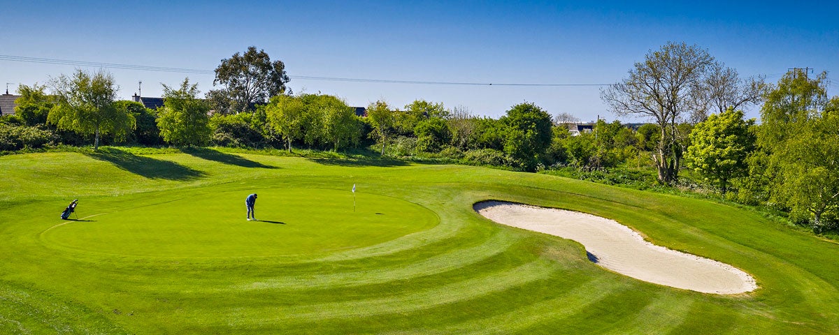 Balbriggan Golf Club player on a green with trees and a sandtrap