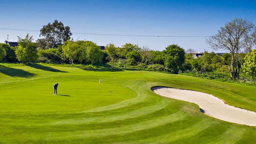 Balbriggan Golf Club player on a green with trees and a sandtrap