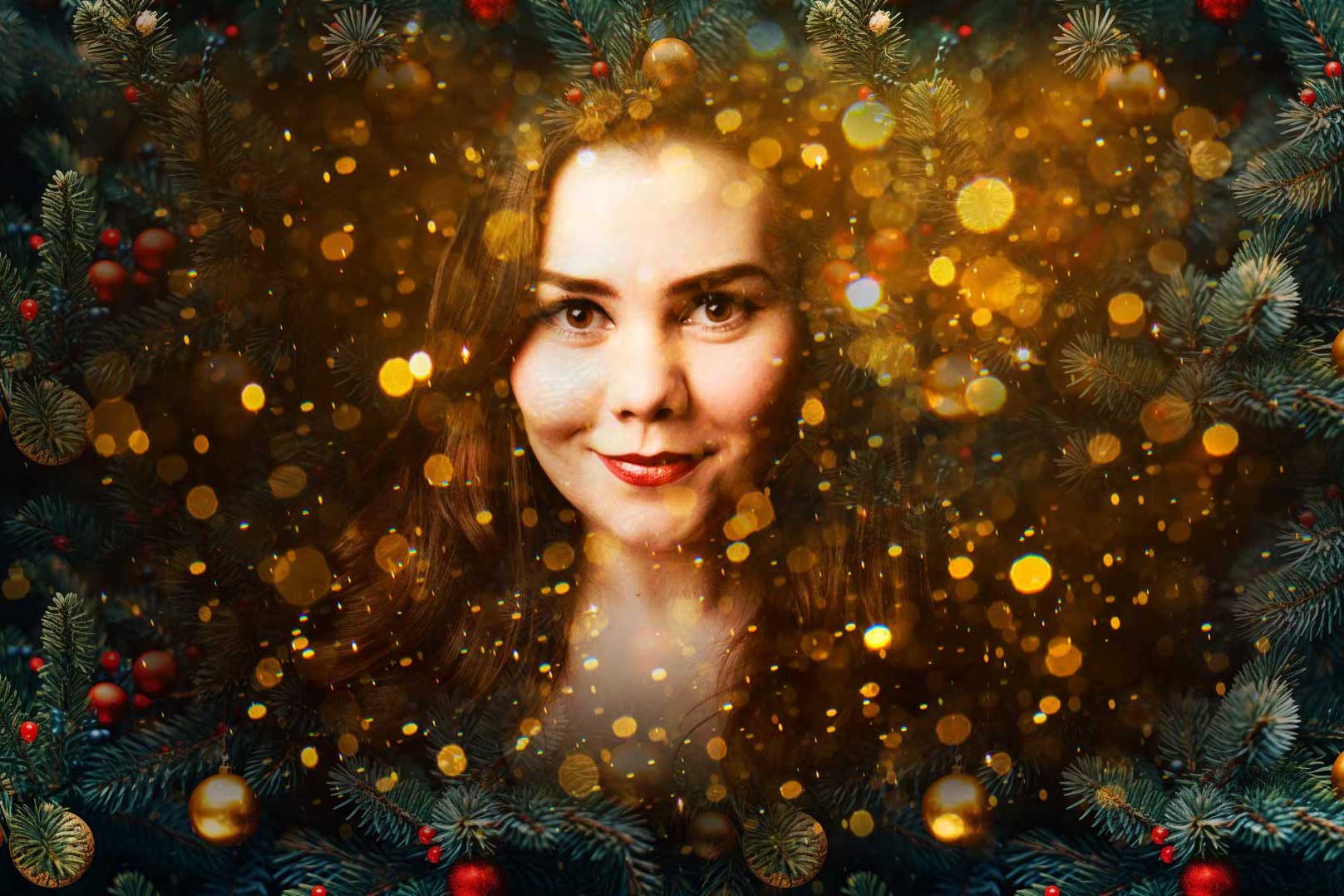 A smiling woman's face is partly obscured by small, gold circles, all surrounded by green pine and baubles from a tree.