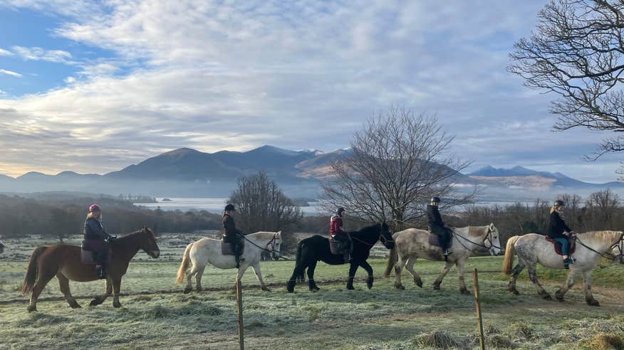 Group riding horses through Killarney in winter.