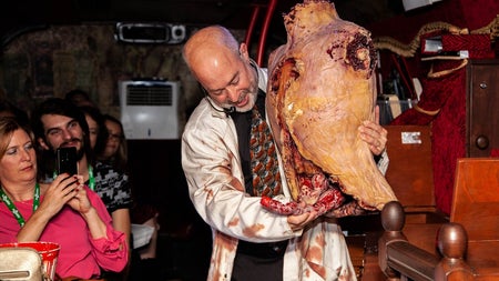 A tour guide holding a gruesome prop