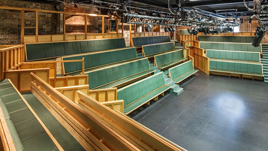 Tiered seats facing a stage in a theatre
