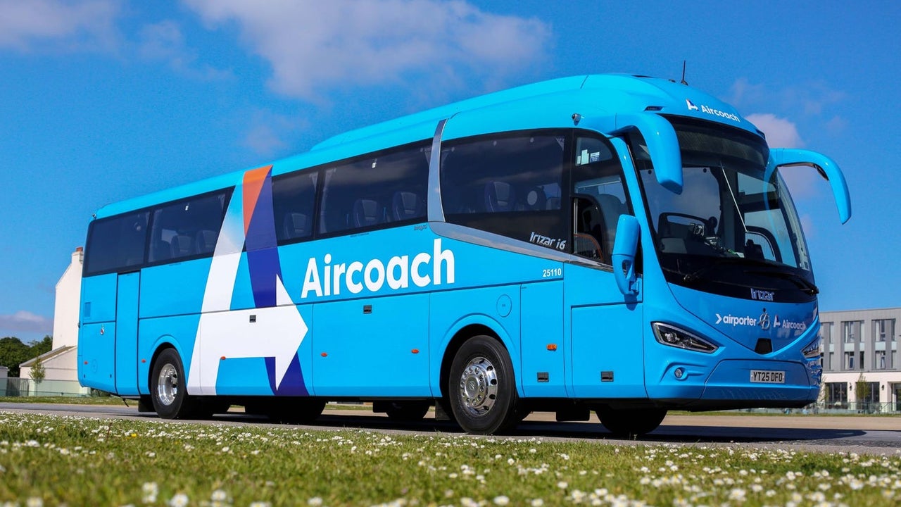 Aircoach bus parked beside a meadow