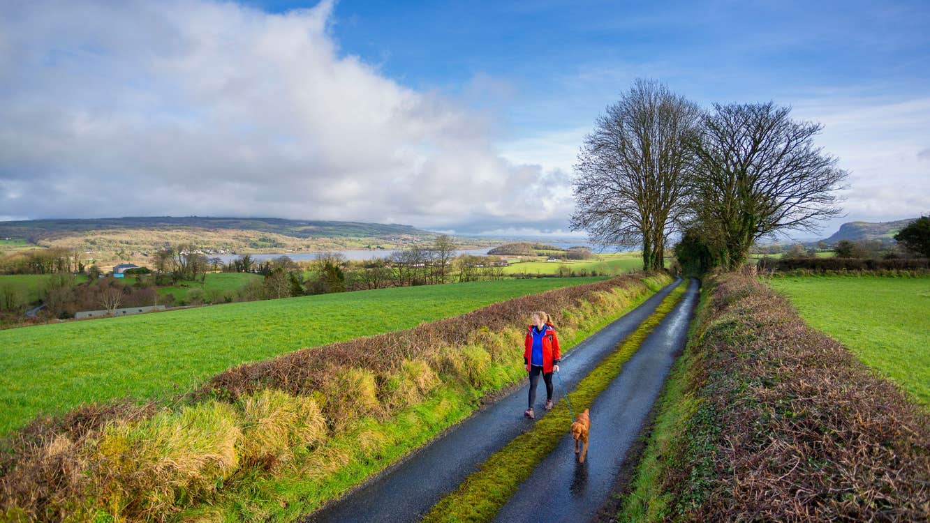Image of a woman walking her dog along the Beara Way